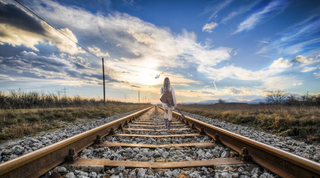 Donna che cammina sola sui binari, spesso è come ci si sente quando si fa diagnosi autismo, ADHD e AuDHD